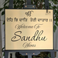 Ek Onkar Punjabi house number sign in gold and black acrylic mounted beside front entrance.