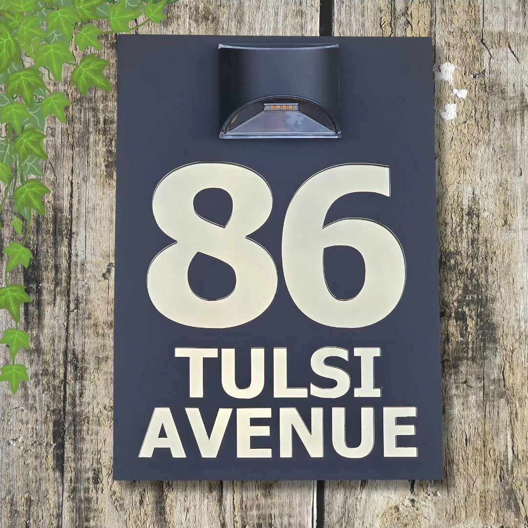 Modern acrylic house number sign with integrated solar light mounted beside a front door, glowing softly at night.