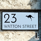 Acrylic house number sign featuring a kangaroo design mounted beside a front door.