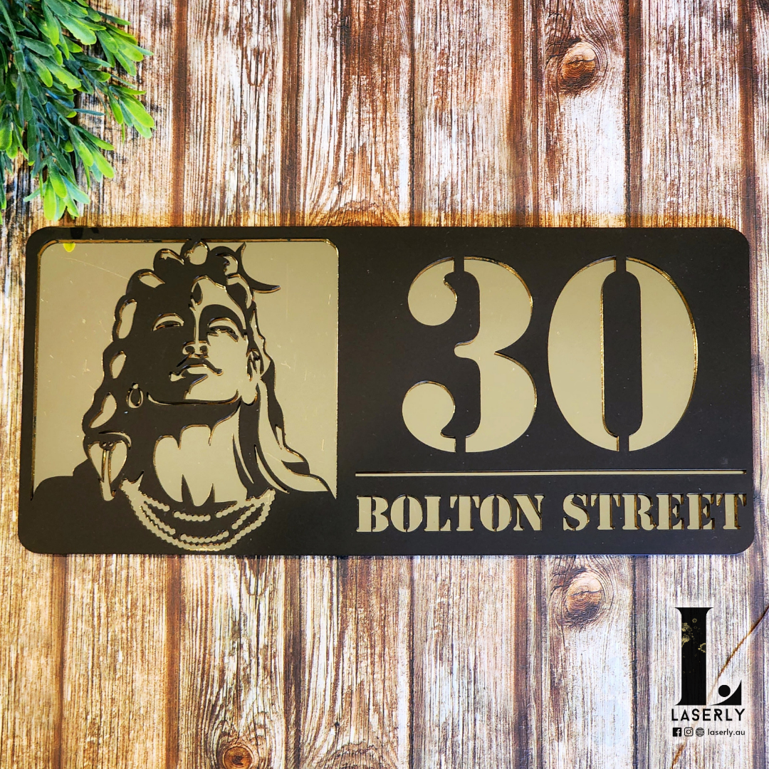 Laser-cut Adiyogi Shiva house plaque beside a contemporary front door.