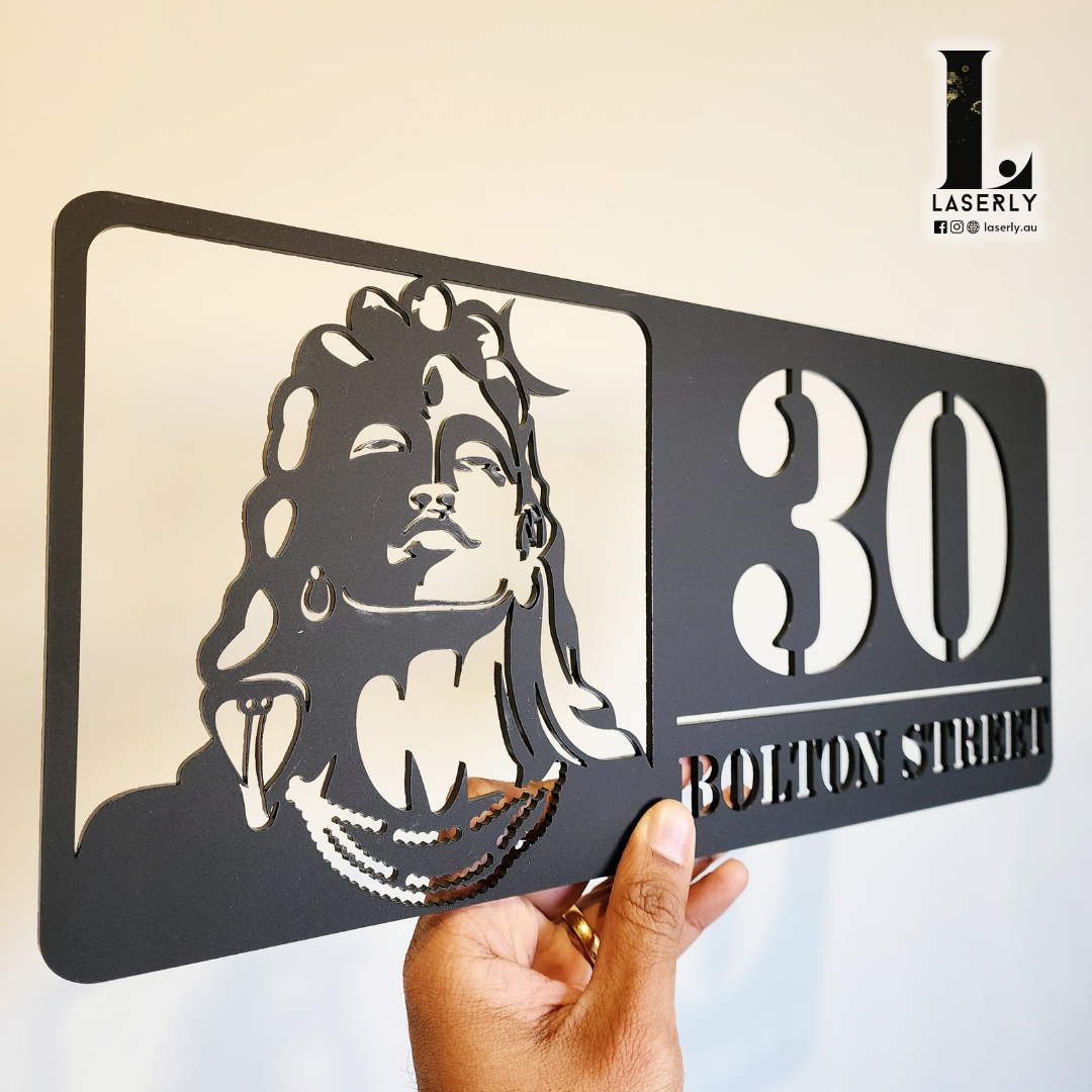 Elegant house number sign featuring Adiyogi Shiva design on home façade.