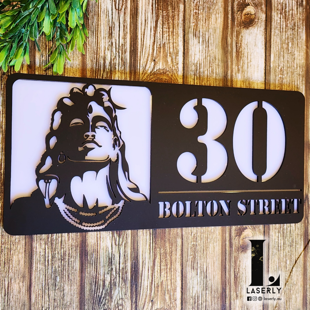 Front entrance adorned with Adiyogi Shiva-inspired house number plaque.