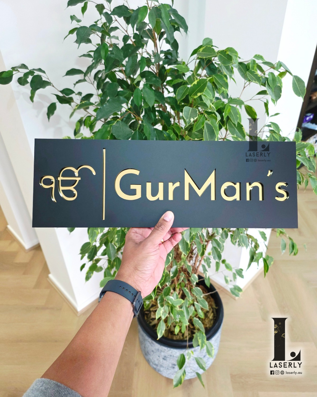 Close-up of black and gold Ek Onkar house number sign on exterior wall.