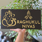 Black and mirror gold Ganesha Namaste house number sign mounted on a modern exterior wall.