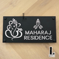 Black and mirror silver Ganesha Namaste house number sign mounted beside a modern front door.