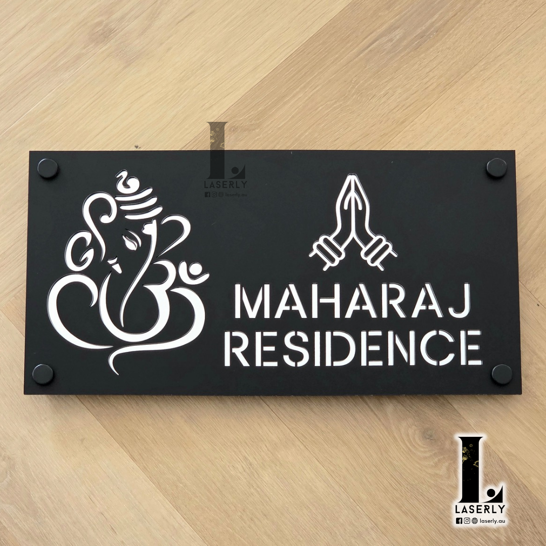 Black and mirror silver Ganesha Namaste house number sign mounted beside a modern front door.