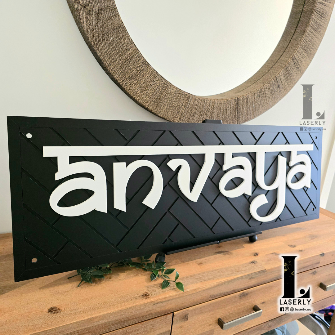 Modern black house name sign featuring intricate patterned design on exterior wall.
