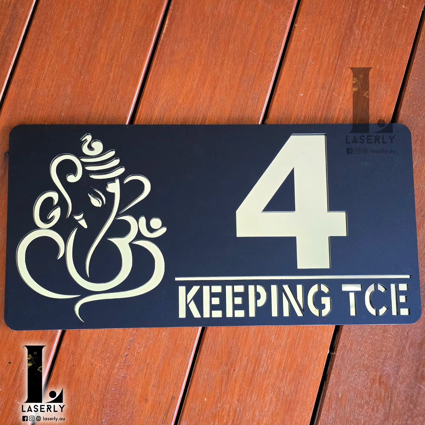 Reflective Ganesha house number sign with elegant black and silver design.