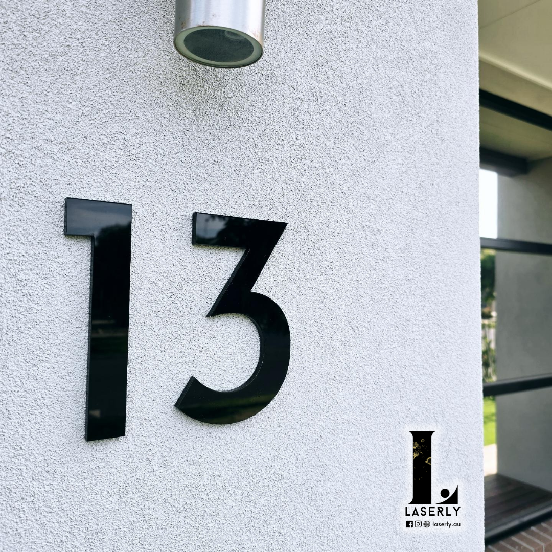 Front door view featuring a stylish black and white house number sign.