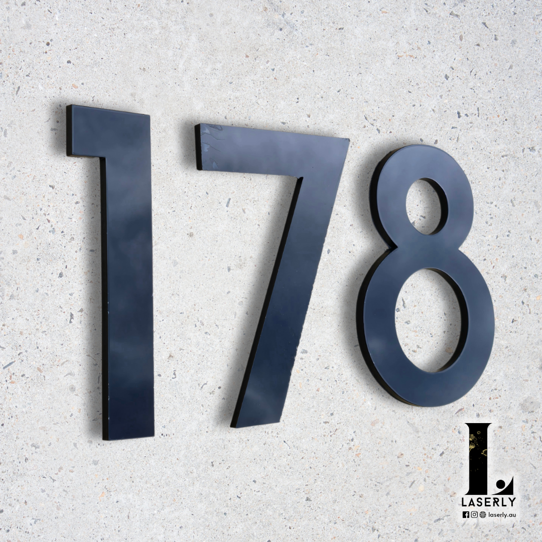 Close-up of black and white house number sign with sharp, readable design.