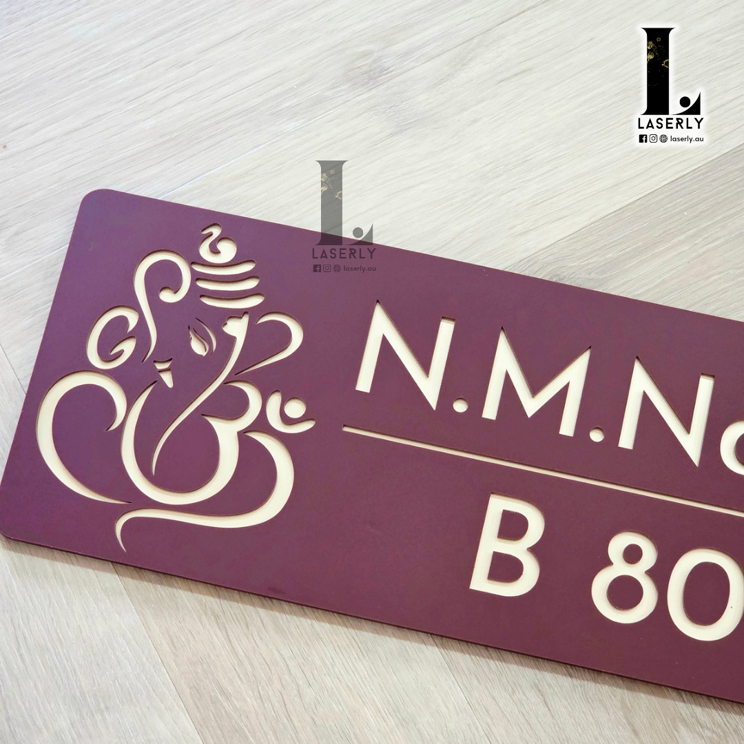 Custom Ganesha house number sign in brown and gold mounted on facade wall.