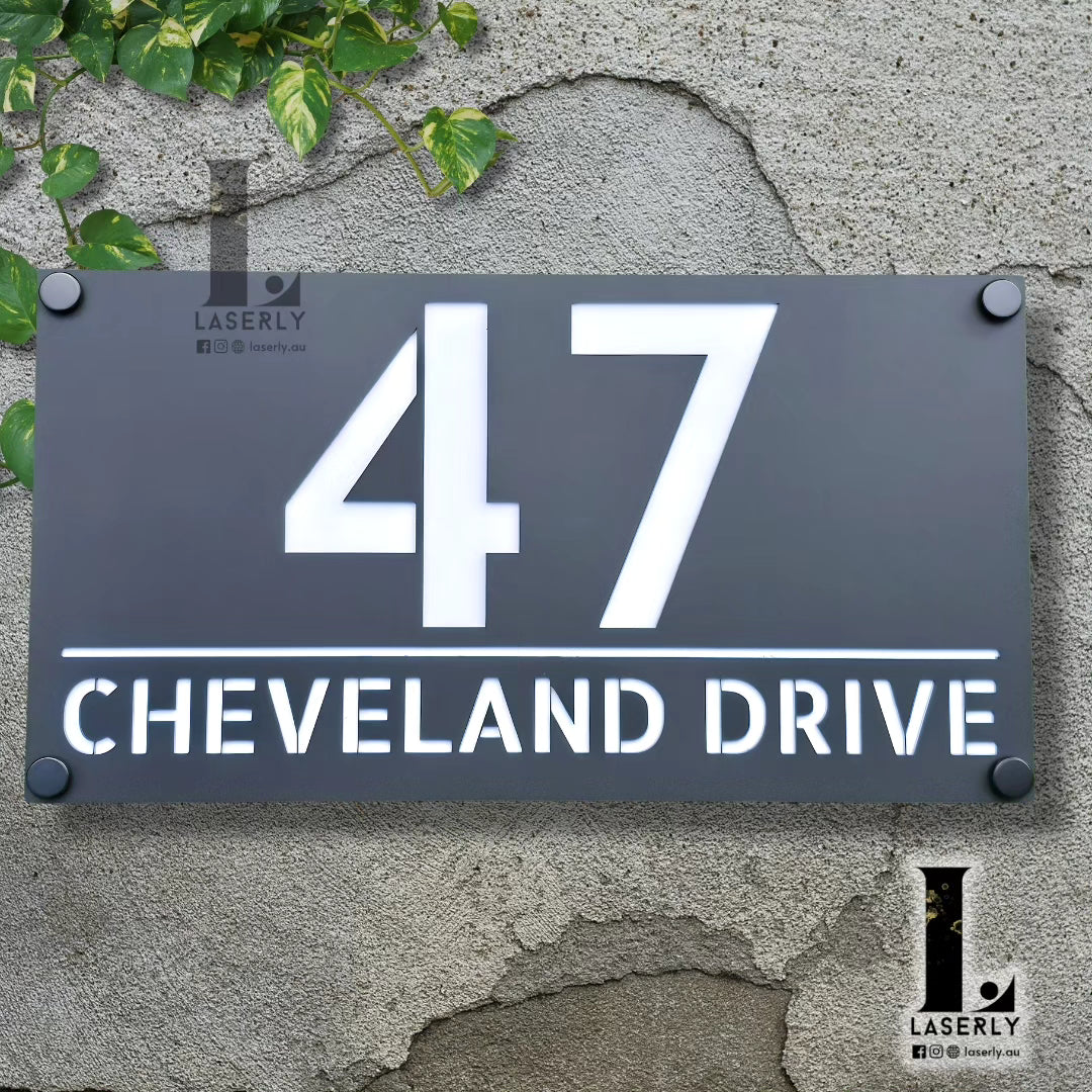 Custom acrylic address plaque with bold house numbers displayed at home entrance.