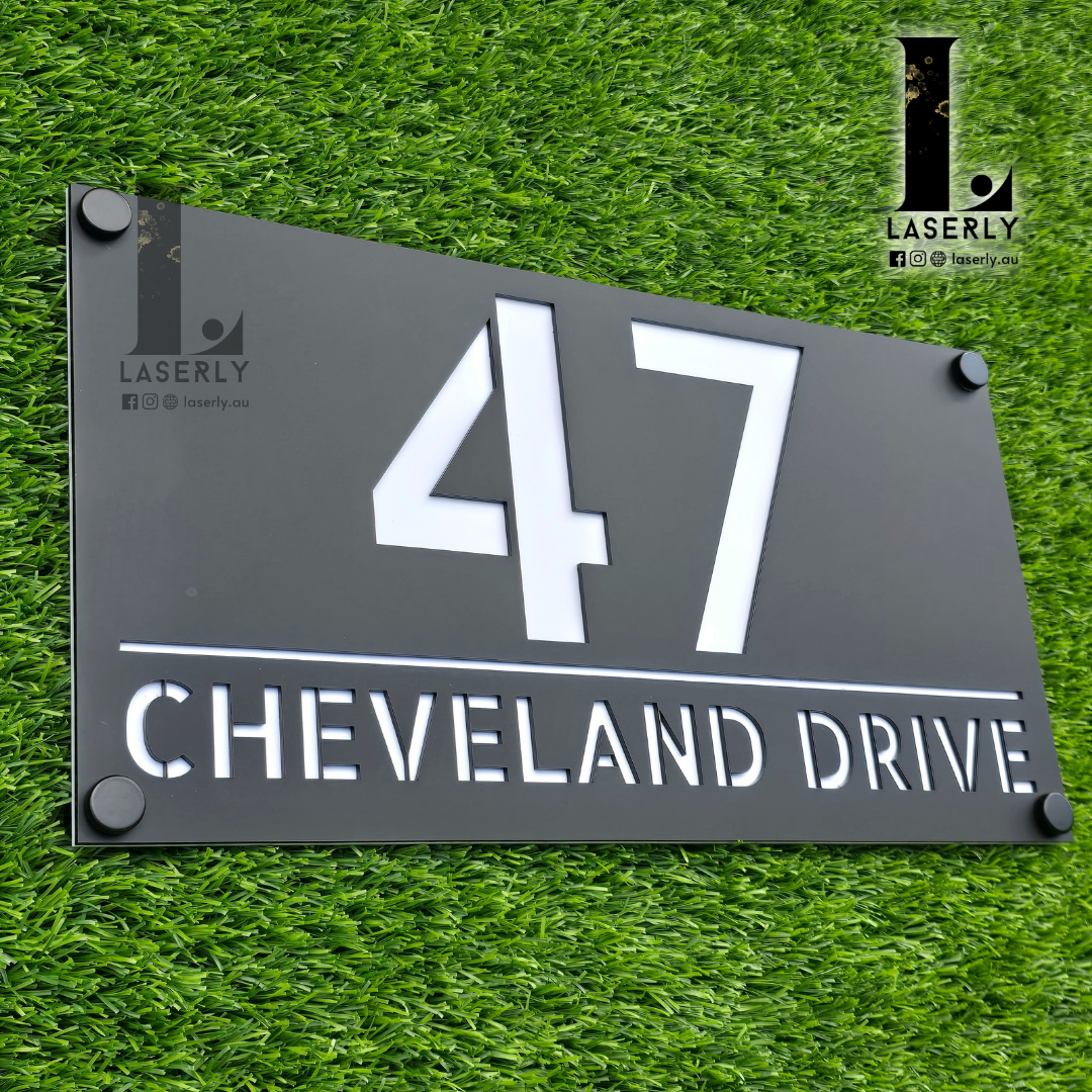 Stylish acrylic house number board mounted on textured exterior wall.