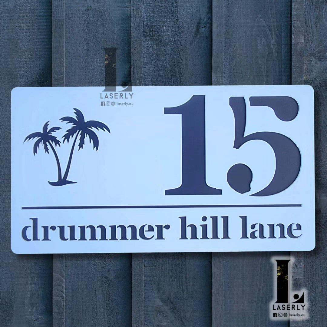 Modern acrylic house number sign featuring a palm tree design, mounted beside a front door.