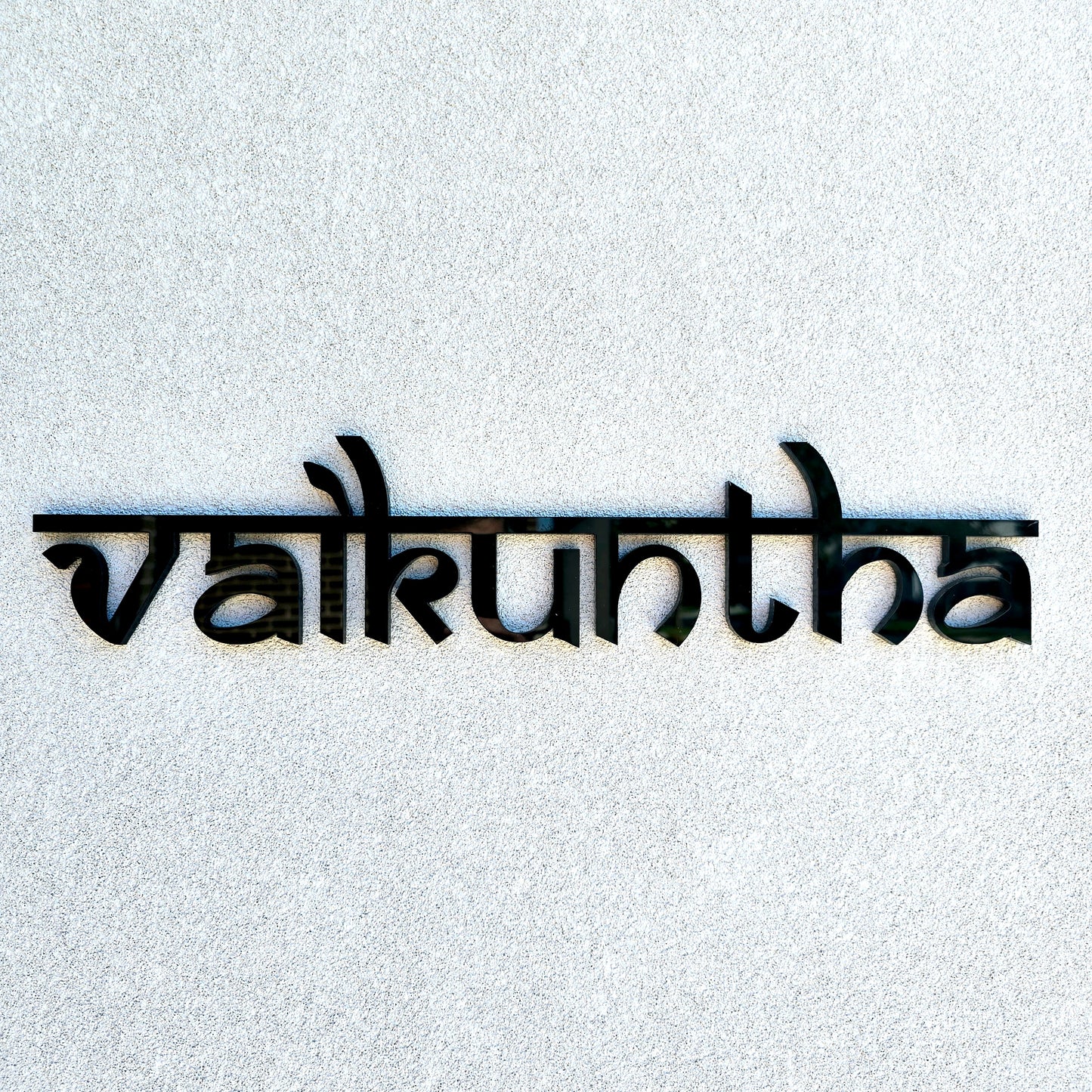 Custom wooden house name sign displayed above a front entrance.