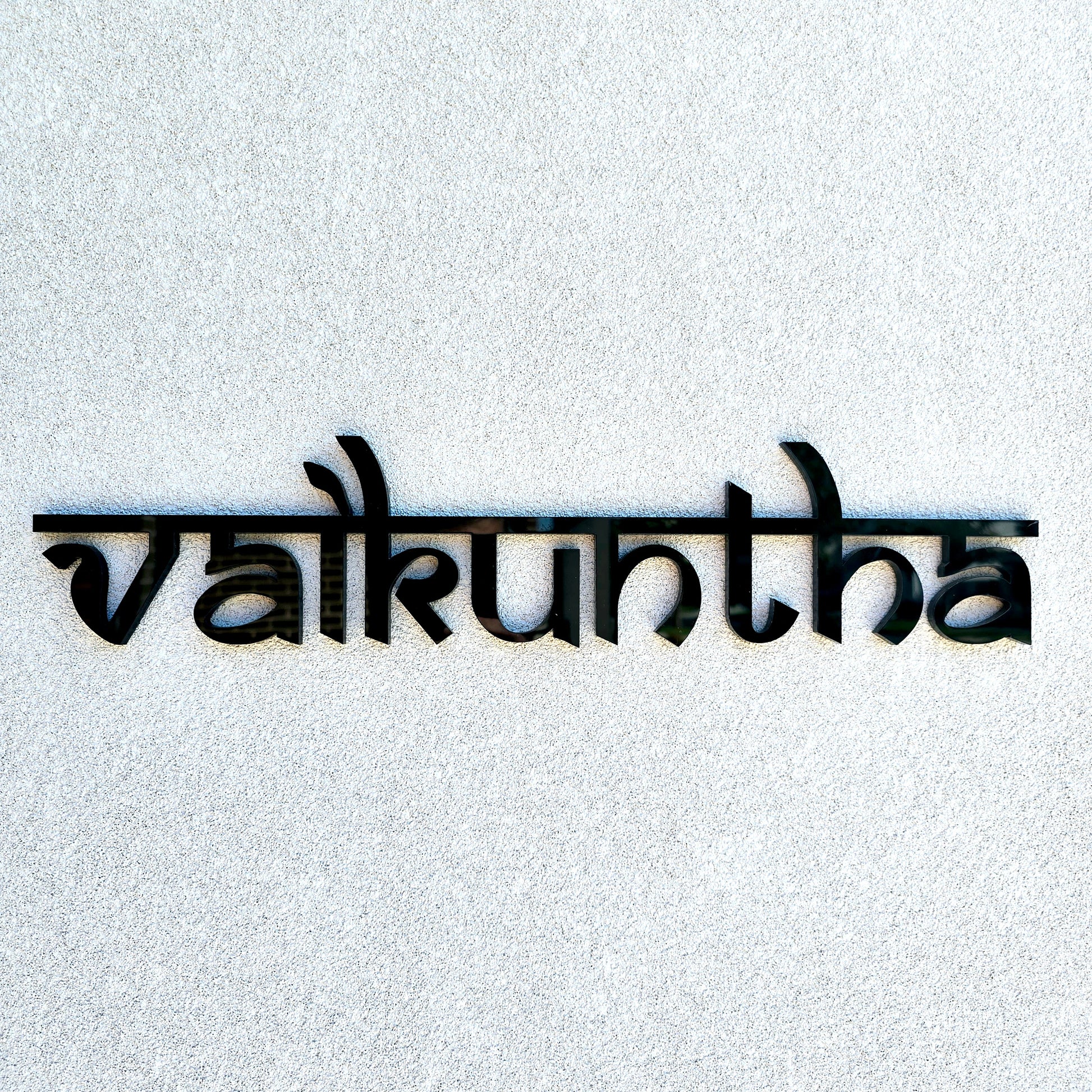 Custom wooden house name sign displayed above a front entrance.