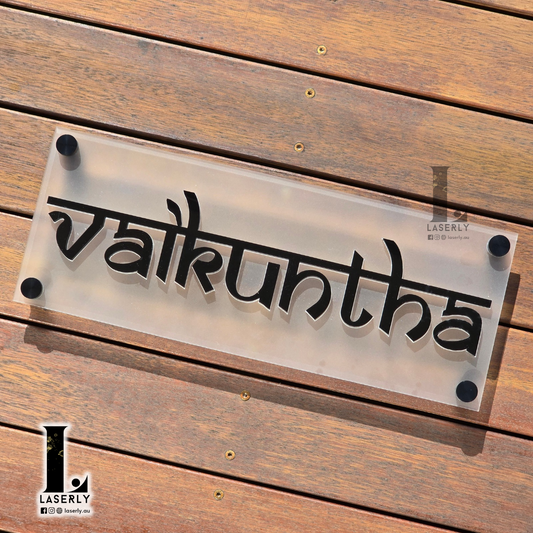 Modern house name sign mounted beside the front door on an exterior wall.