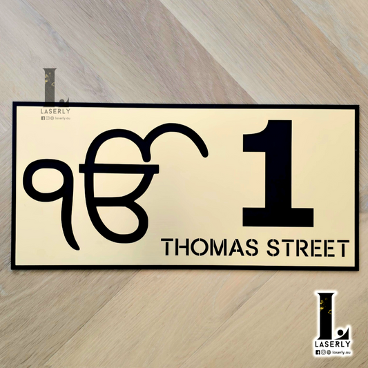 Ek Onkar house number sign in gold acrylic mounted beside modern home entrance.