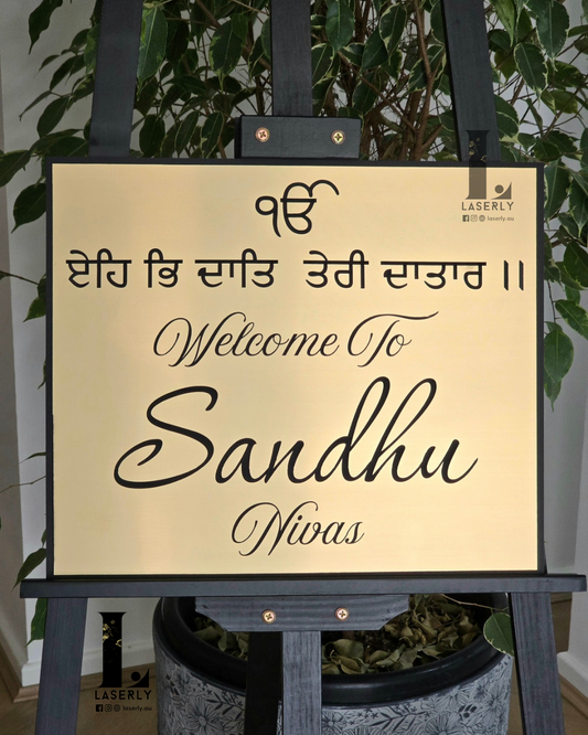 Ek Onkar Punjabi house number sign in gold and black acrylic mounted beside front entrance.