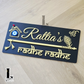 Modern black house number plaque with flute motif and blue evil eye detail beside front door.