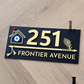 Laser-cut black acrylic house number sign with flute pattern and evil eye accent for home entrance.