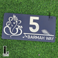 Laser-cut spiritual house number sign with Ganesha and Krishna motif beside front door.