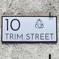 Sleek Ganesha-themed house number plate in minimalistic style beside front door.
