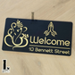 Modern Ganesha Namaste house number plaque with detailed laser-cut artwork displayed on exterior wall.