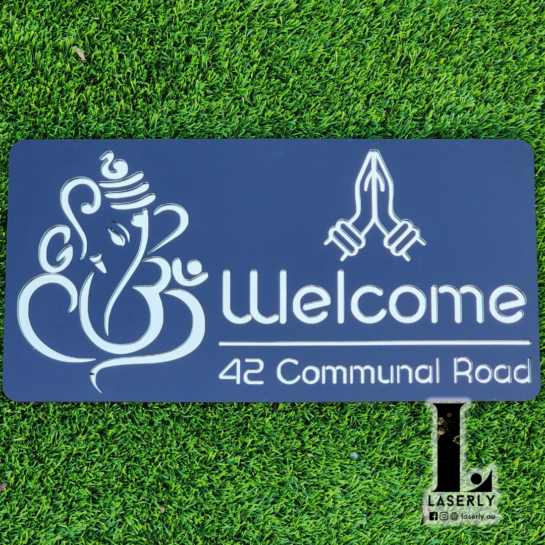 Laser-cut Ganesha Namaste home address sign with intricate detailing fixed on outdoor facade.