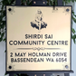 Elegant Sai Baba house sign in gold and black acrylic on wall.