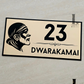 Modern gold and black Saibaba house number sign mounted beside front door.