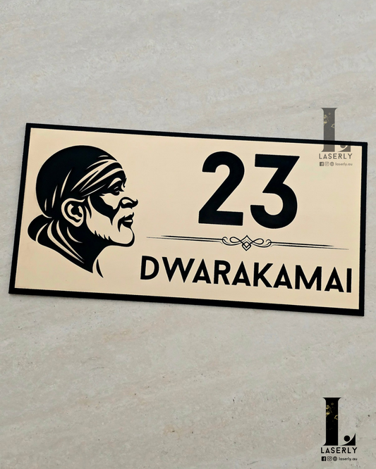 Modern gold and black Saibaba house number sign mounted beside front door.