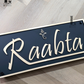 Elegant gold layered Ganesha design on matte black acrylic house number plaque for home entrance.