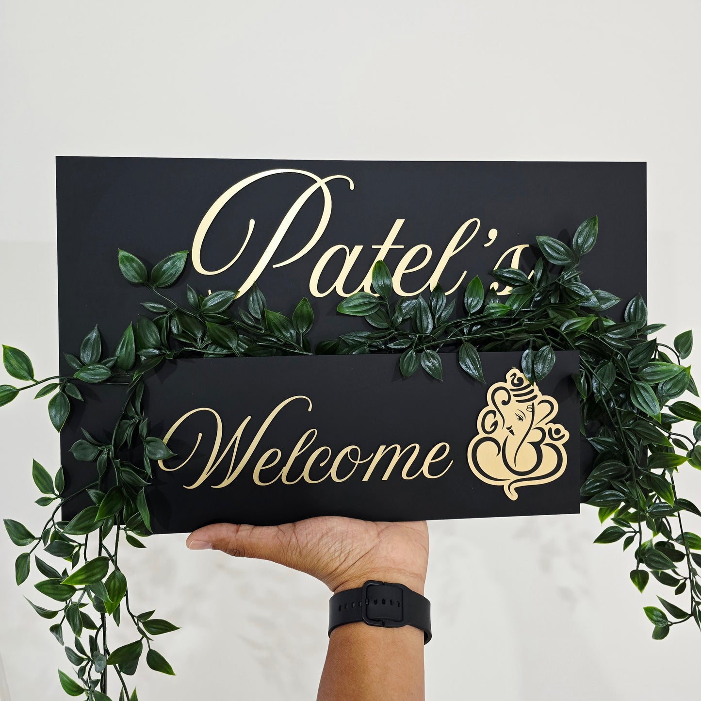 Acrylic house number plaque with Ganesha artwork and small planter box installed near the front door.