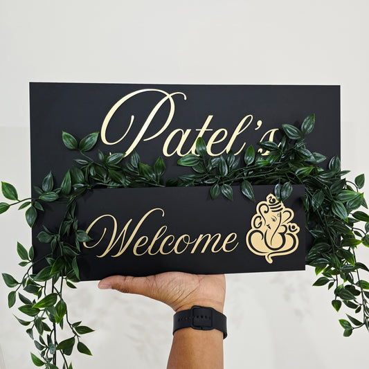 Acrylic house number plaque with Ganesha artwork and small planter box installed near the front door.