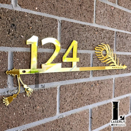 Modern house number sign featuring Lord Krishna’s flute design mounted beside the front door.