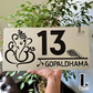 Decorative Ganesha-Krishna house number sign in steel-look acrylic, mounted on exterior wall.