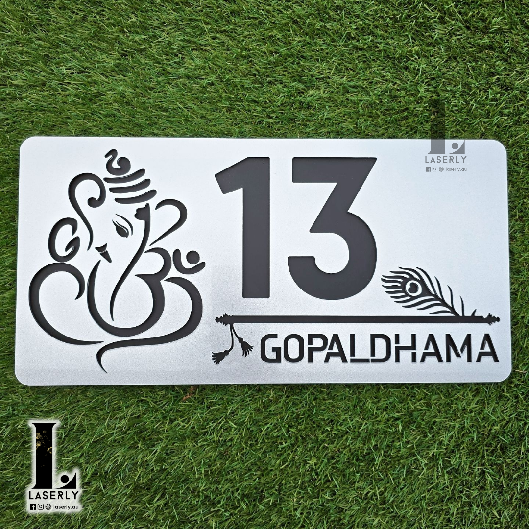 Acrylic house number with intricate Ganesha and Krishna flute motif, steel-finish style.