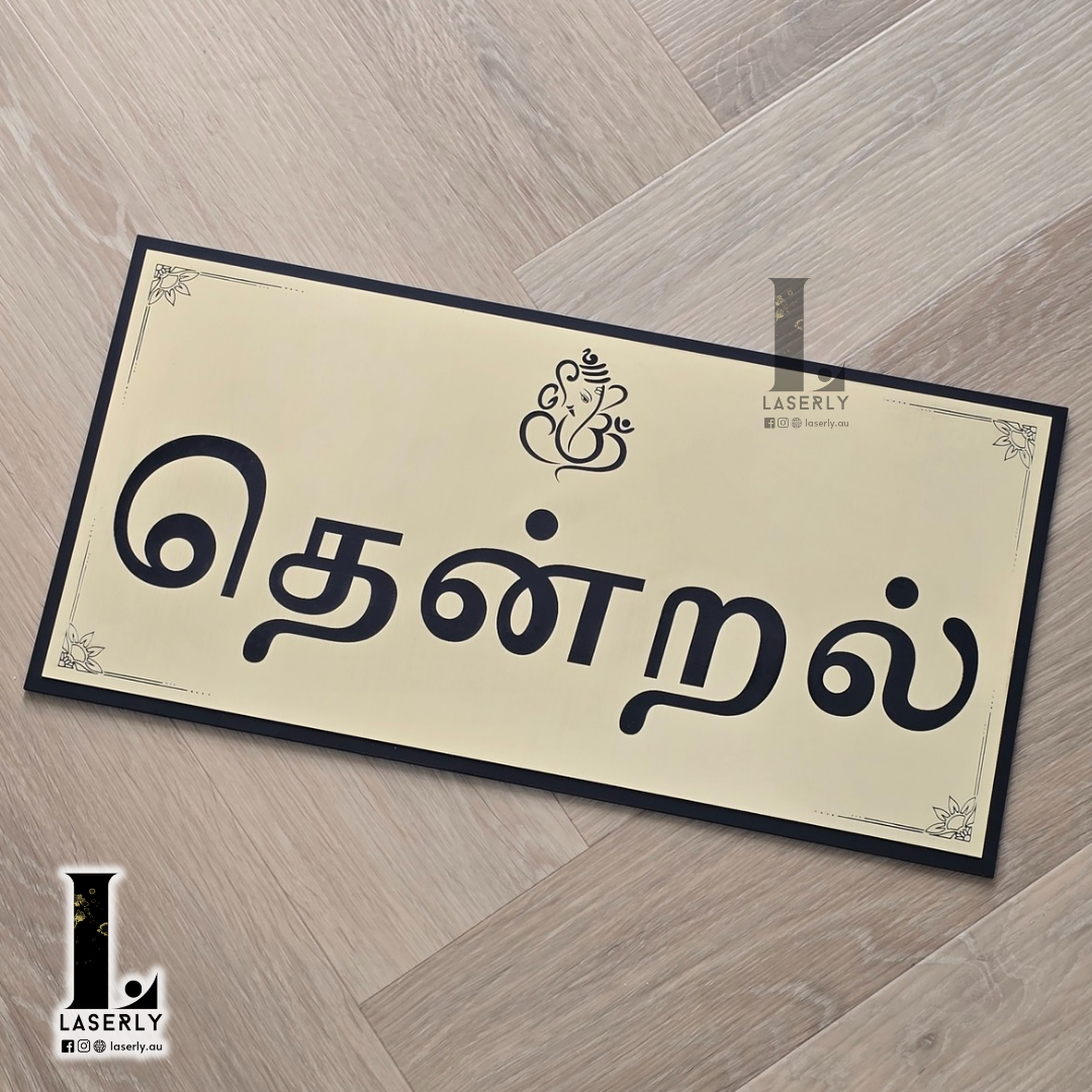 Elegant laser-cut Ganesha house sign displaying Tamil family name outside home.