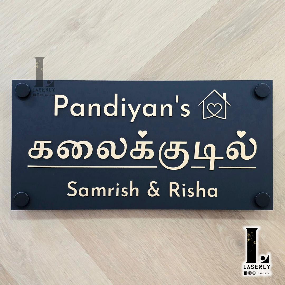 Tamil house number sign in elegant Tamil script mounted beside the front door on an exterior wall.