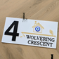 White exterior house number sign decorated with symbolic evil eye.