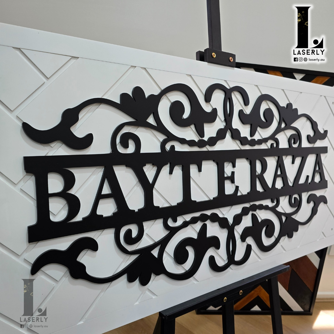 Stylish white home nameplate featuring detailed patterns on a residential wall.