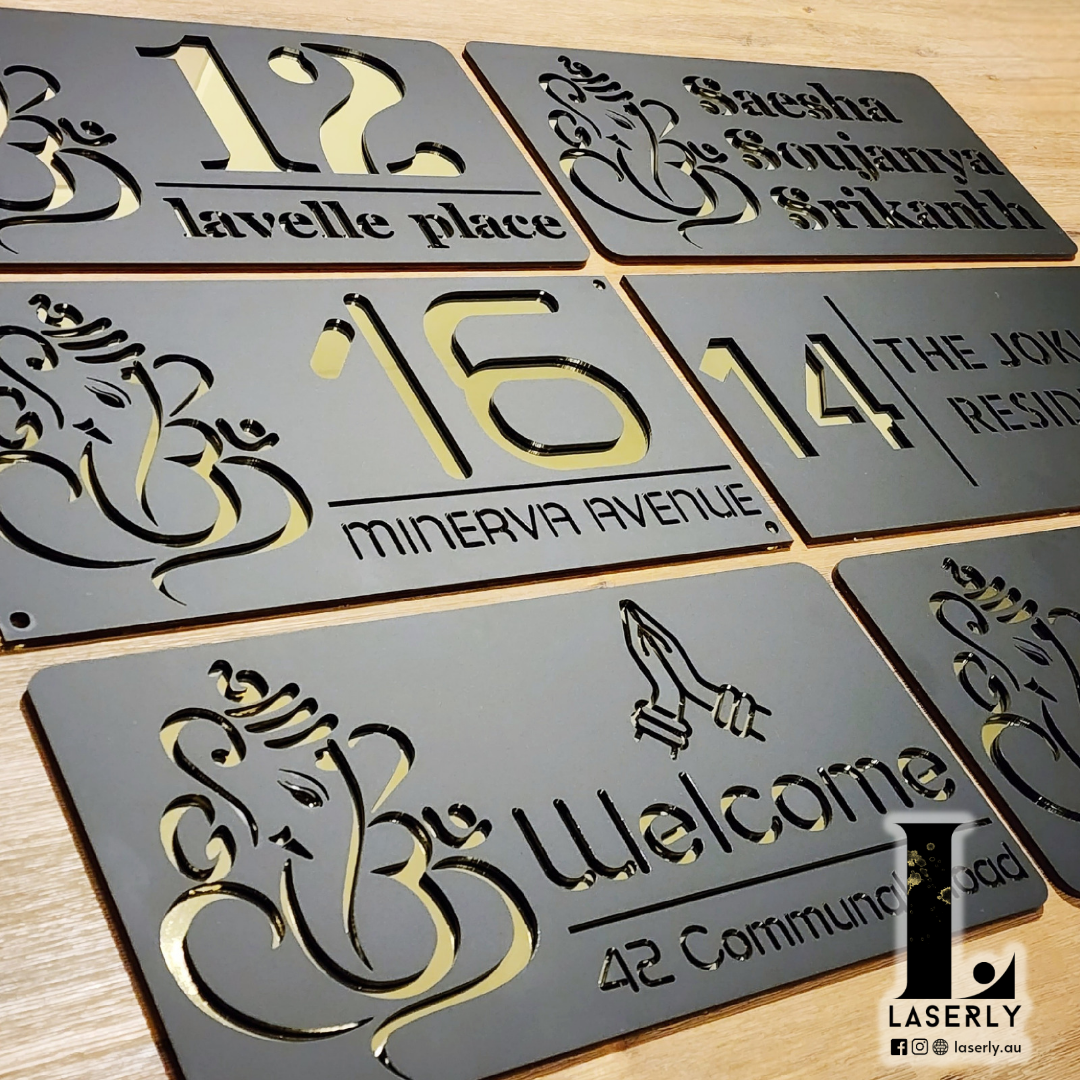 Laser-cut Ganesha house number sign mounted beside a modern front door with elegant acrylic finish.